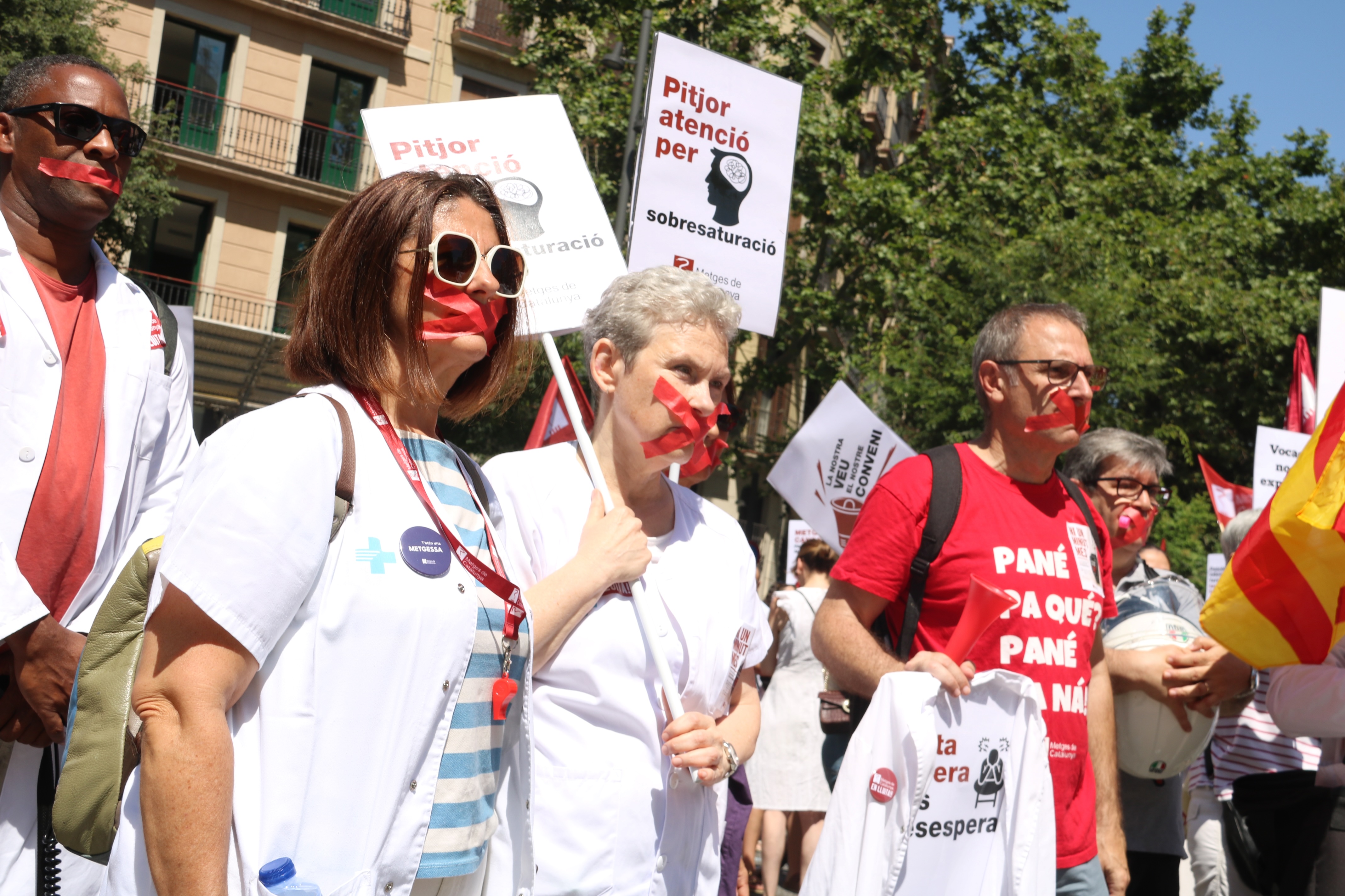 Doctors taking part in the Barcelona protest with tape over their mouths