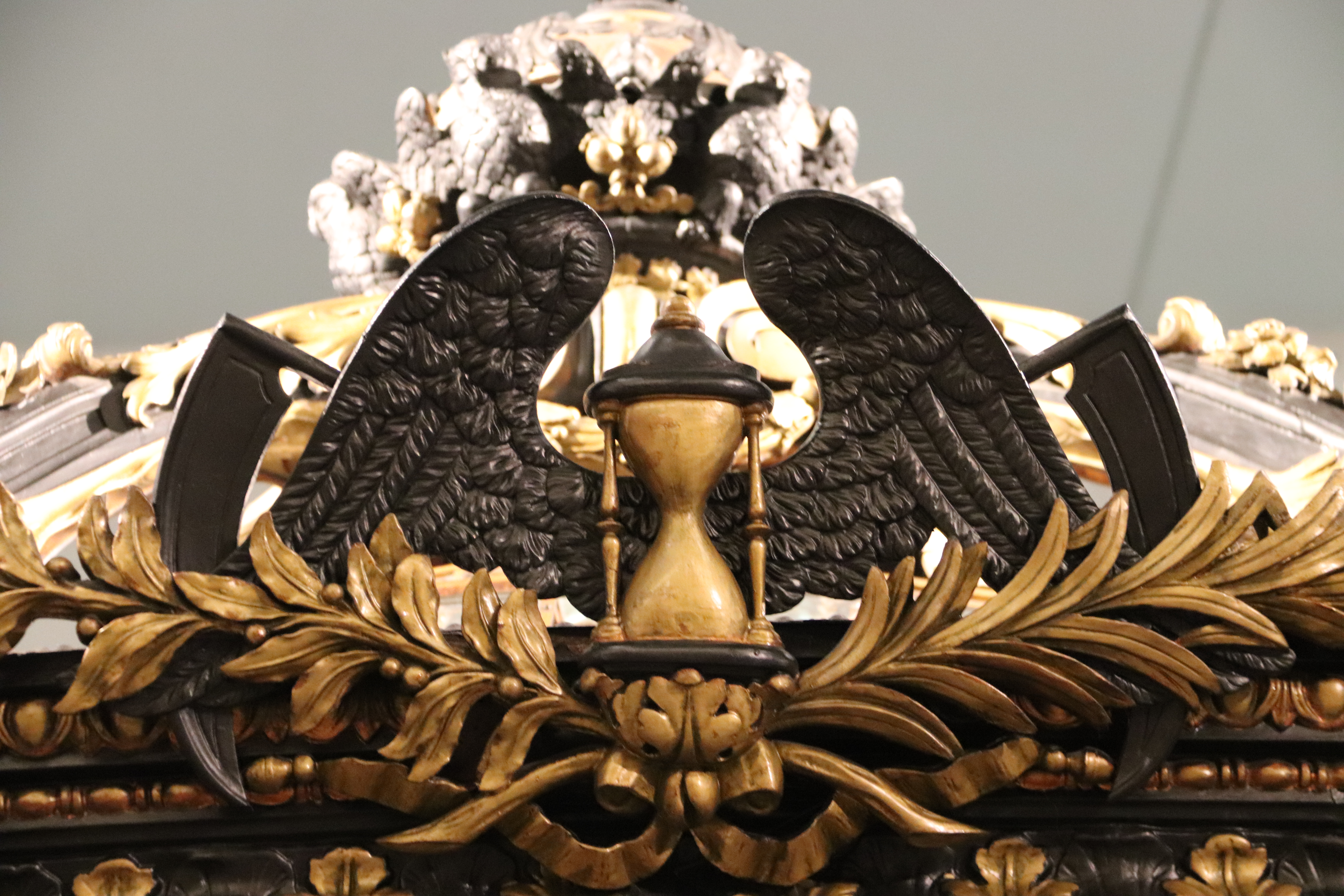 A winged hourglass, used to symbolize Tempus Fugit in funeral carriages