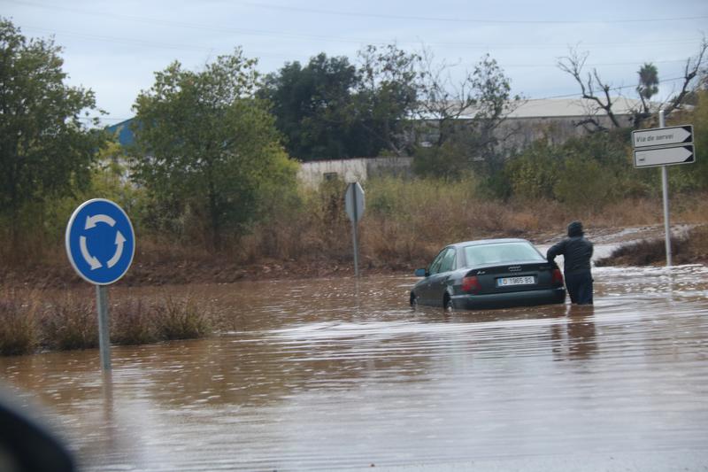 A man pushes a car in Ulldecona, one of the municipalities affected by the episode of heavy downpours.