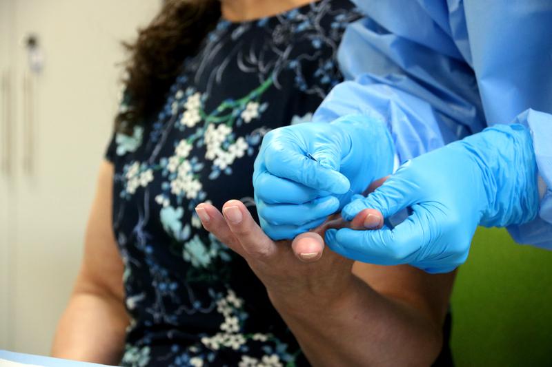 A nurse takes a blood sample from one of the Colombians searching for disappeared family members