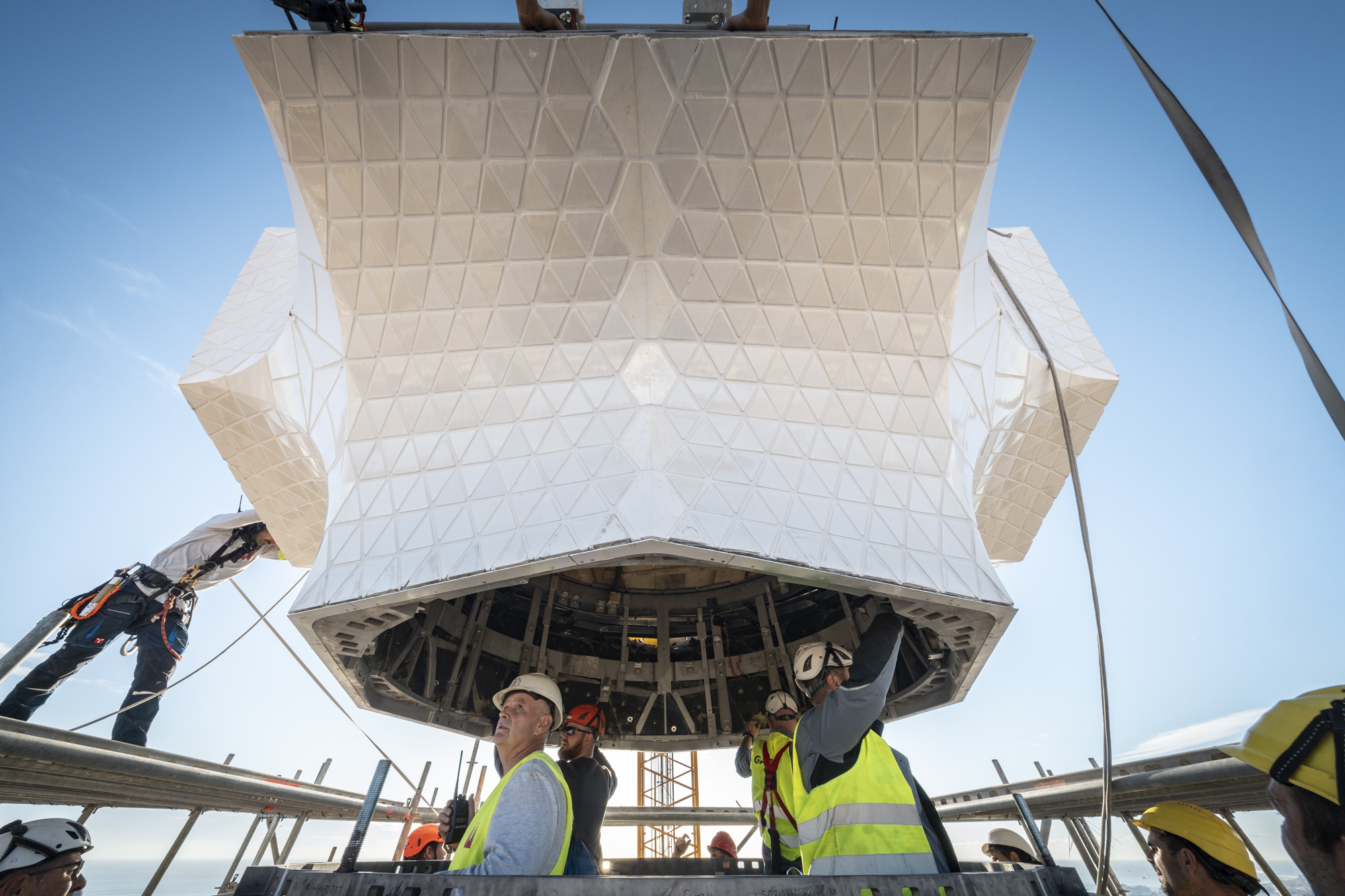 Workers install the central element of the cross atop the Sagrada Família’s Tower of Jesus Christ