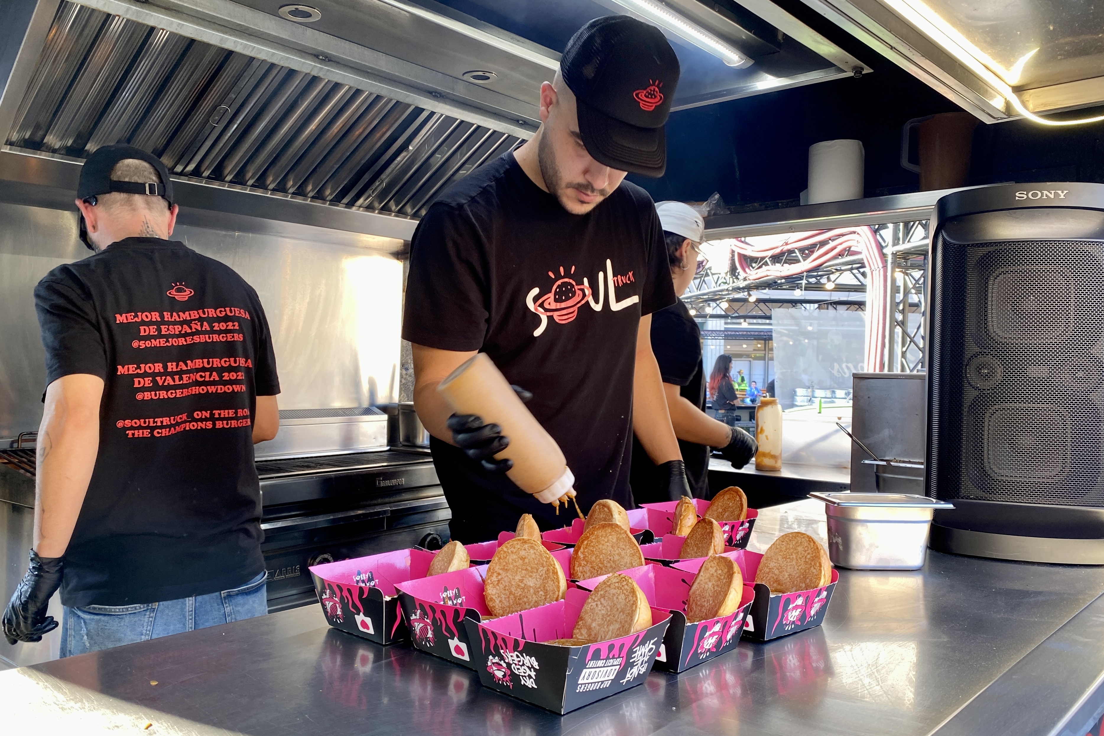 A cook preparing several burgers at The Champions Burger food festival on May 15, 2024 in Barcelona