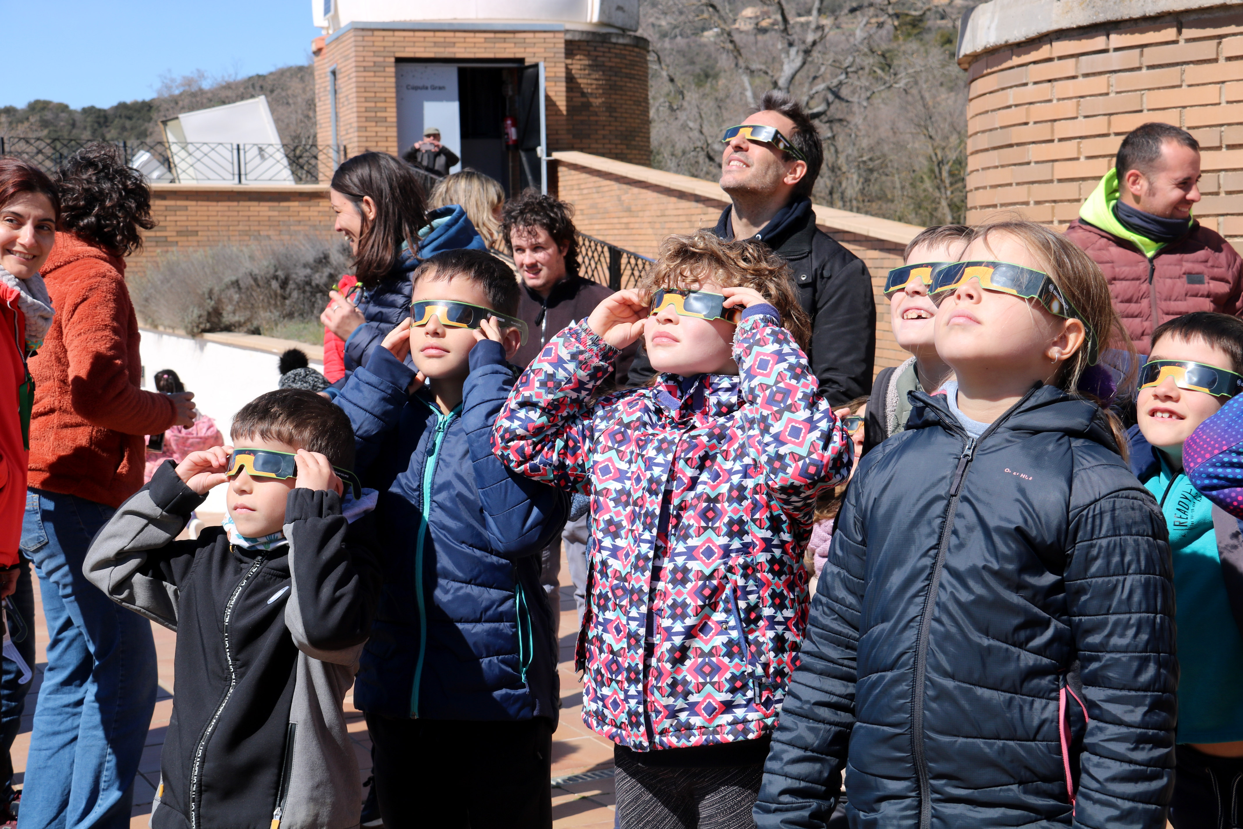A group of children wearing eclipse ready glasses observe a partial solar eclipse from Catalonia's Astronomic Park in Montsec on March 29, 2025