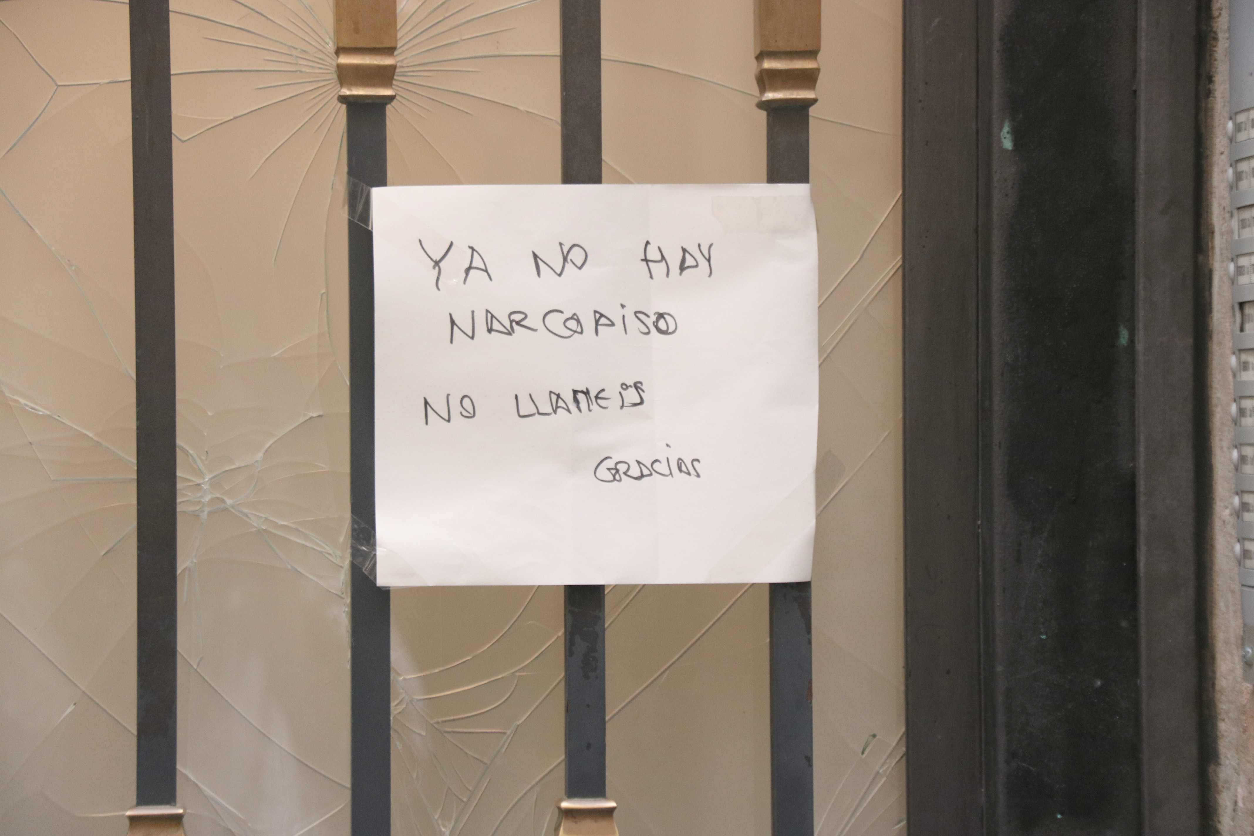 A sign on the front door of the building where a drug den operated reads: 'No drug den anymore, do not call'