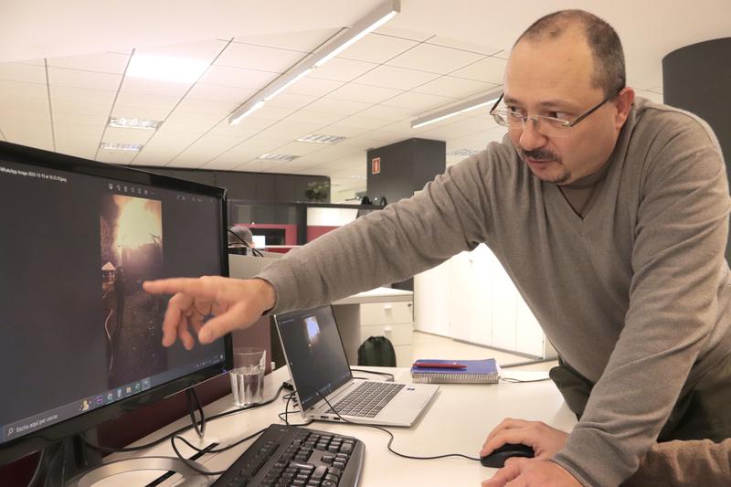 Russian dissident Andrei Paniushkin shows images of his house burning