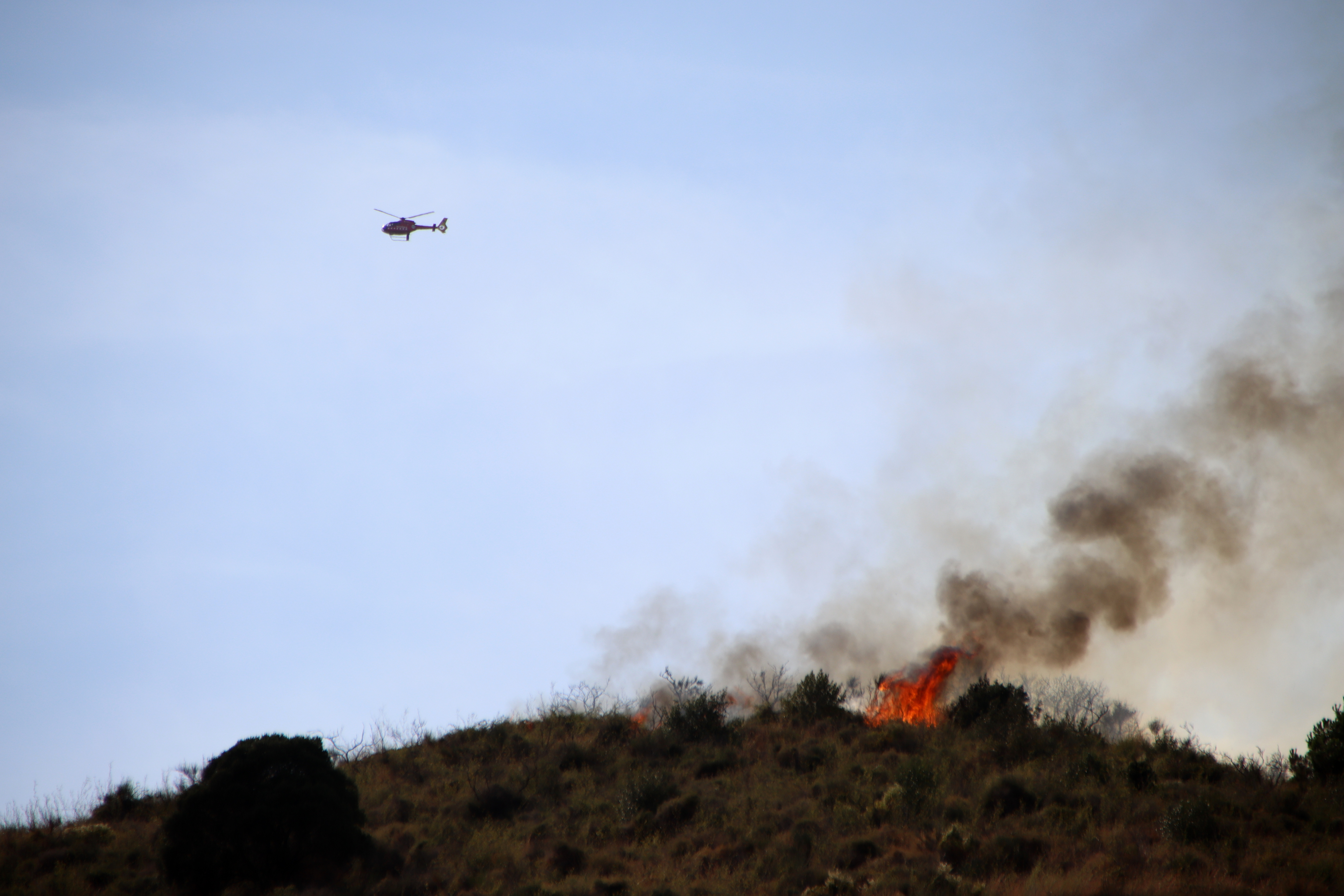 Flames visible on Collserola with a helicopter overhead