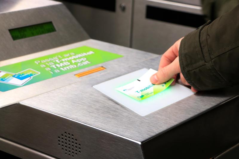 A public transport user uses the T-mobilitat rechargeable card in a Barcelona metro station