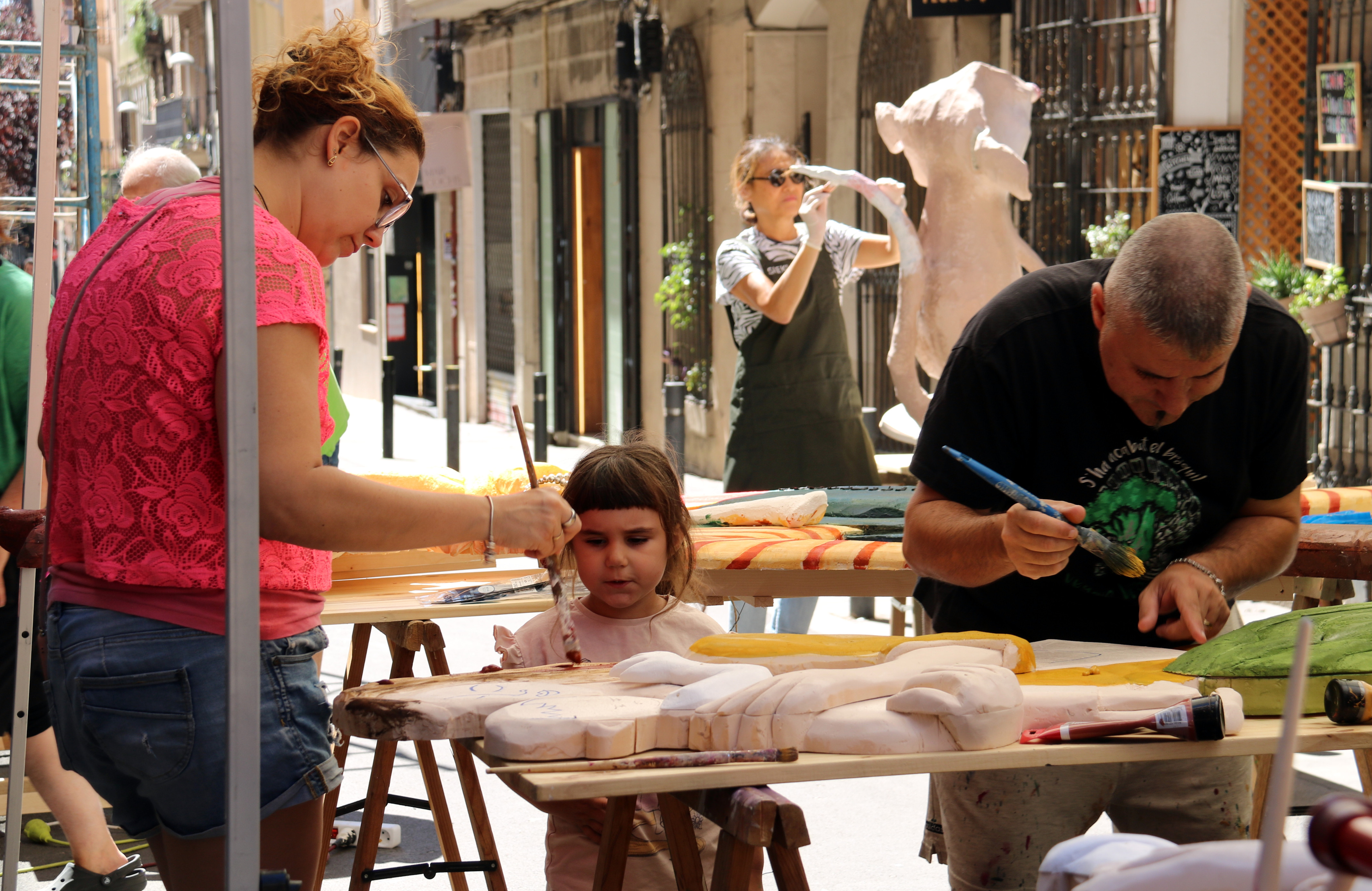 A family working on the decorations for Festes de Gràcia in Carrer Verdi