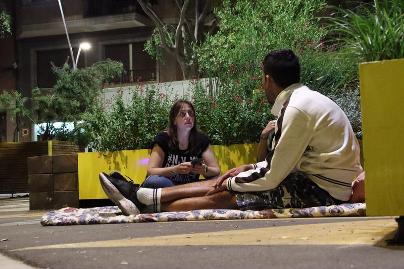 Two Arrels volunteers talk to Omar, who sleeps on the streets in Barcelona