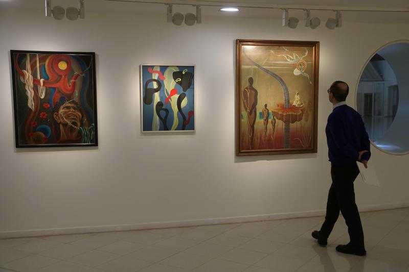 A person looks at one of the paintings by Helios Gómez donated to the MNAC by the artist's son