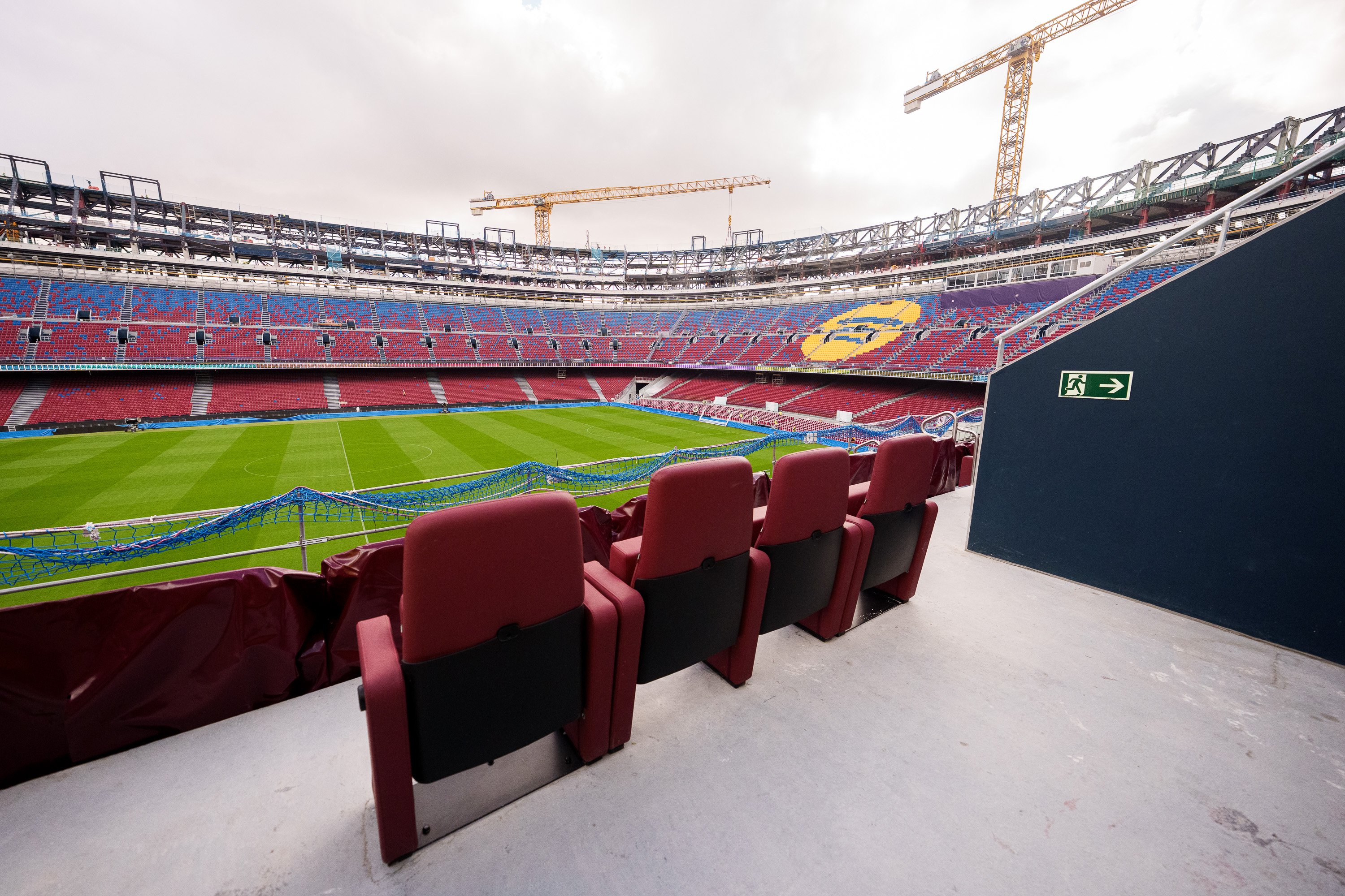 Detail of the VIP stands of FC Barcelona's Spotify Camp Nou with several cranes in the background