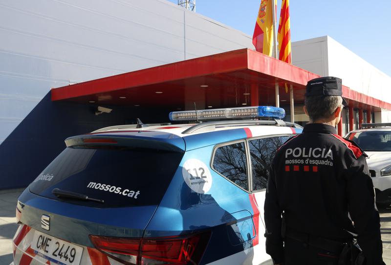 A Catalan Mossos d'Esquadra police officer beside a patrol car in front of one of the Mossos buildings on February 3, 2023
