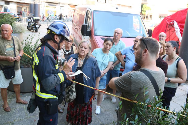 A firefighter briefs shop owners affected by the Putxet sinkhole ahead of inspections of their premises