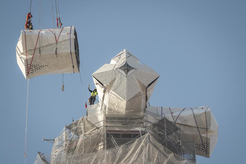 Construction workers install the fourth arm of the cross-alike viewpoint of the Tower of Jesus Christ of the Sagrada Família in Barcelona