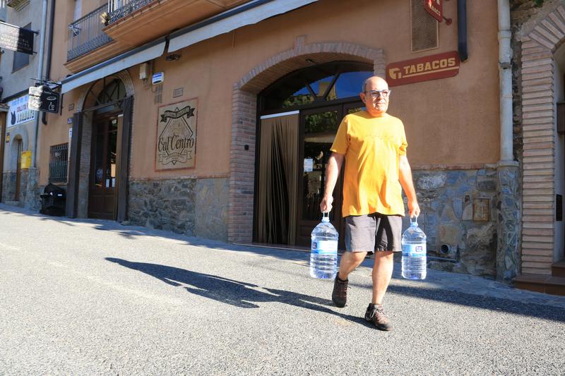 Joan, a neighbor of Vilella Baixa, carrying bottled water in his home town