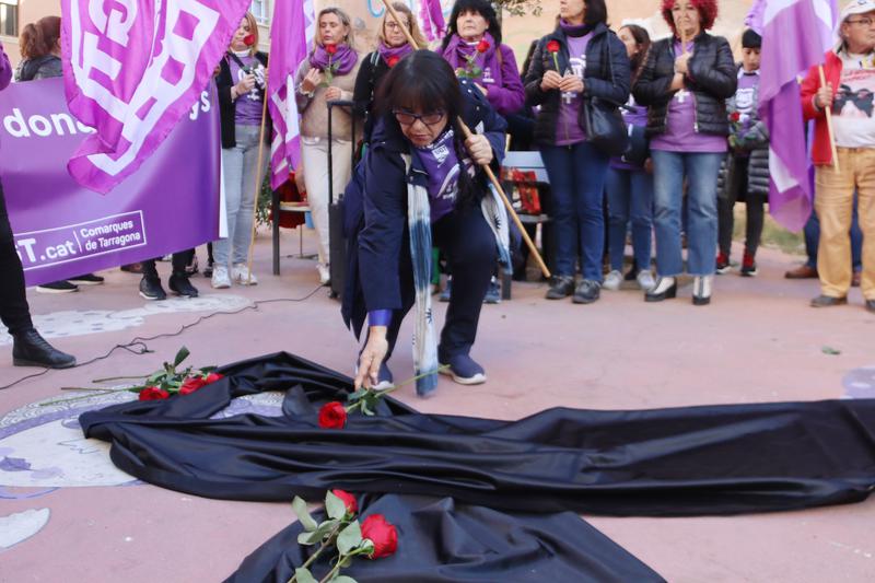 A woman places a rose to pay tribute to the victims of gender-based violence on November 25