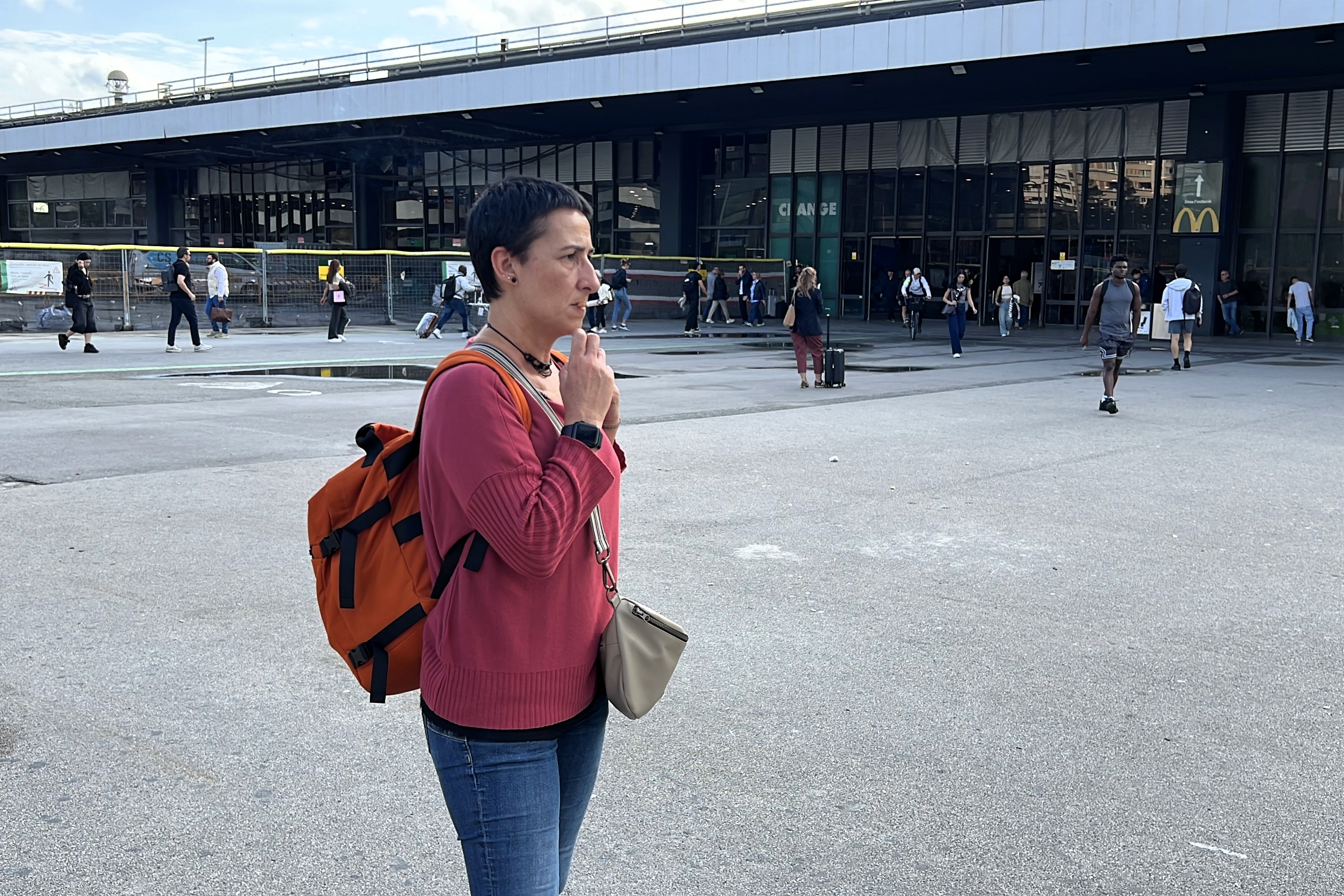A woman smokes a cigarette outside Barcelona-Sants train station