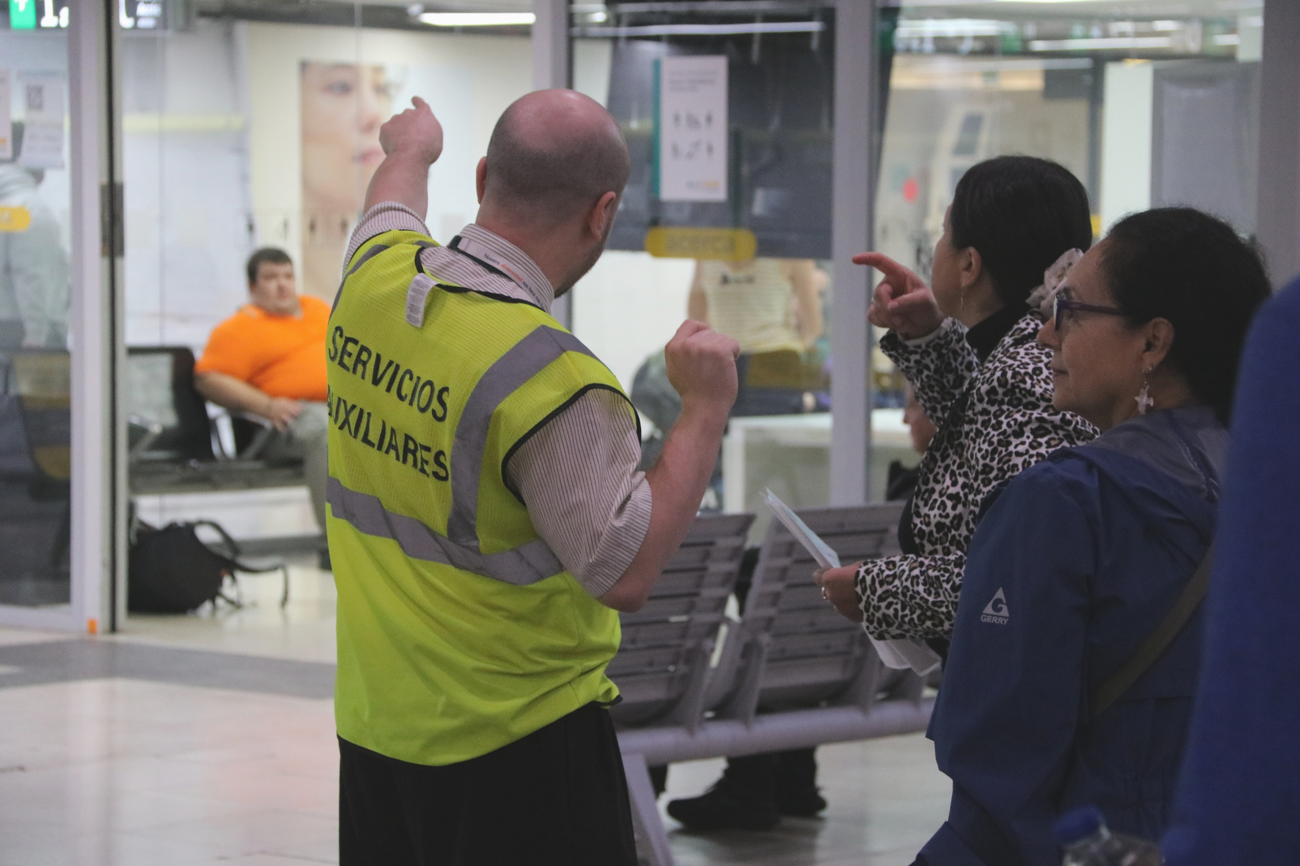 A staff member explains the situation to a passenger at Sants station