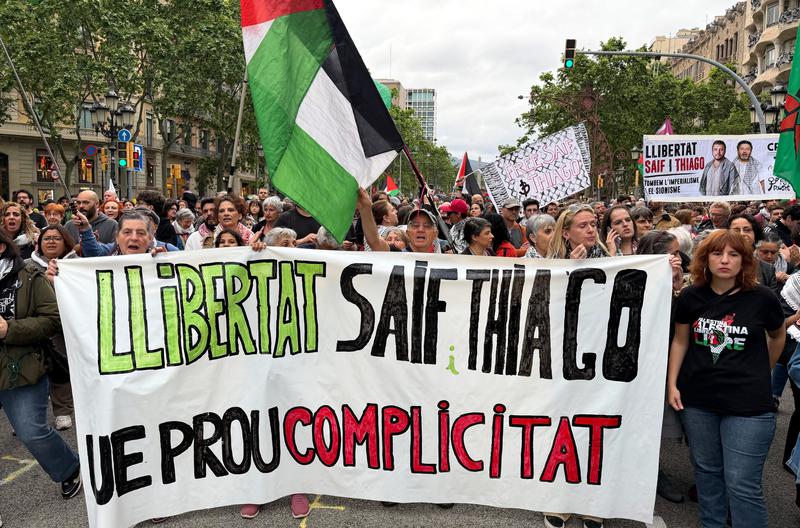 Protesters display a banner demanding the freedom of two pro-Palestinian activists detained by Israel and calling for the EU's involvement in Barcelona.