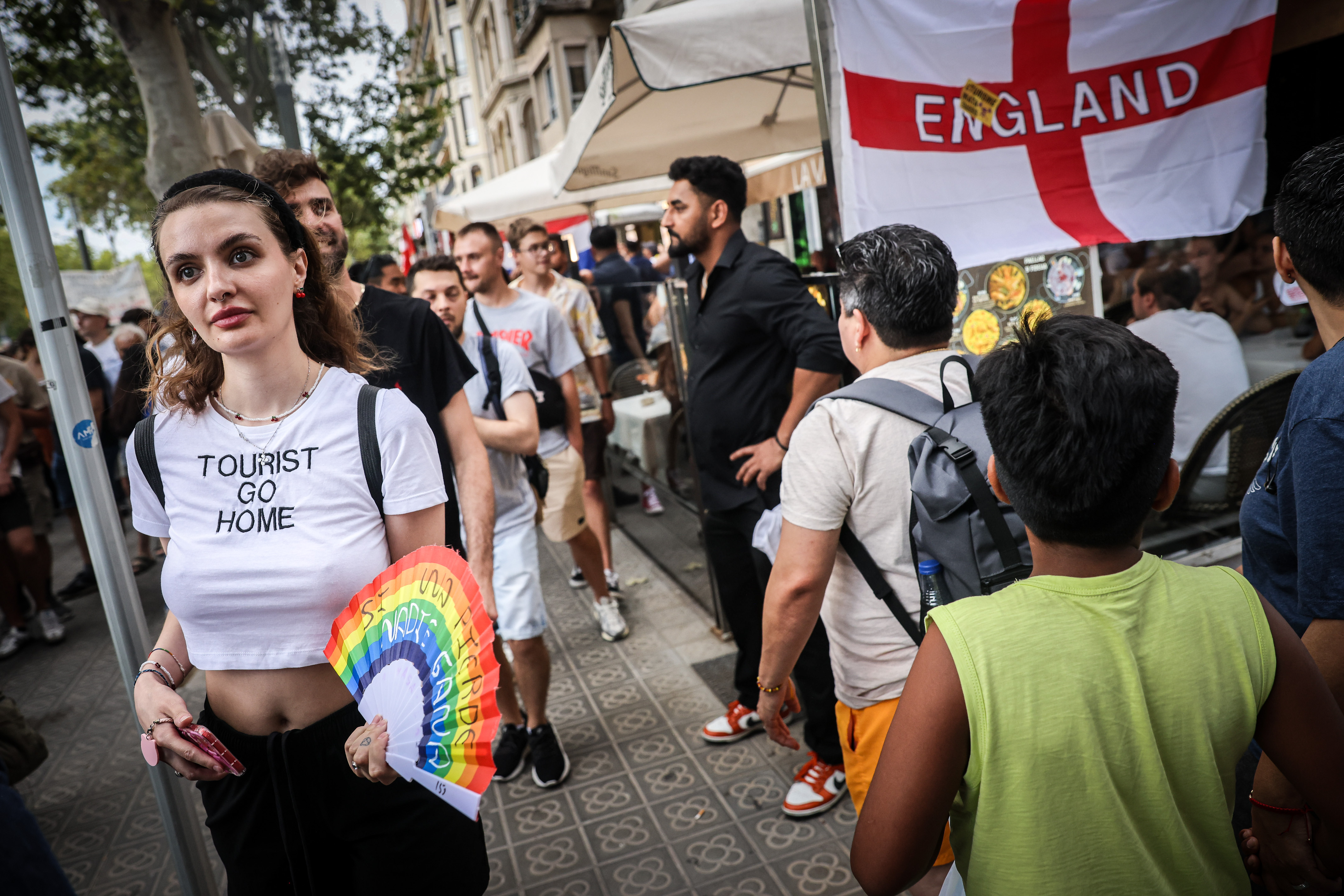 A woman wears a 'Tourist Go Home' t-shirt during a protest in Barcelona