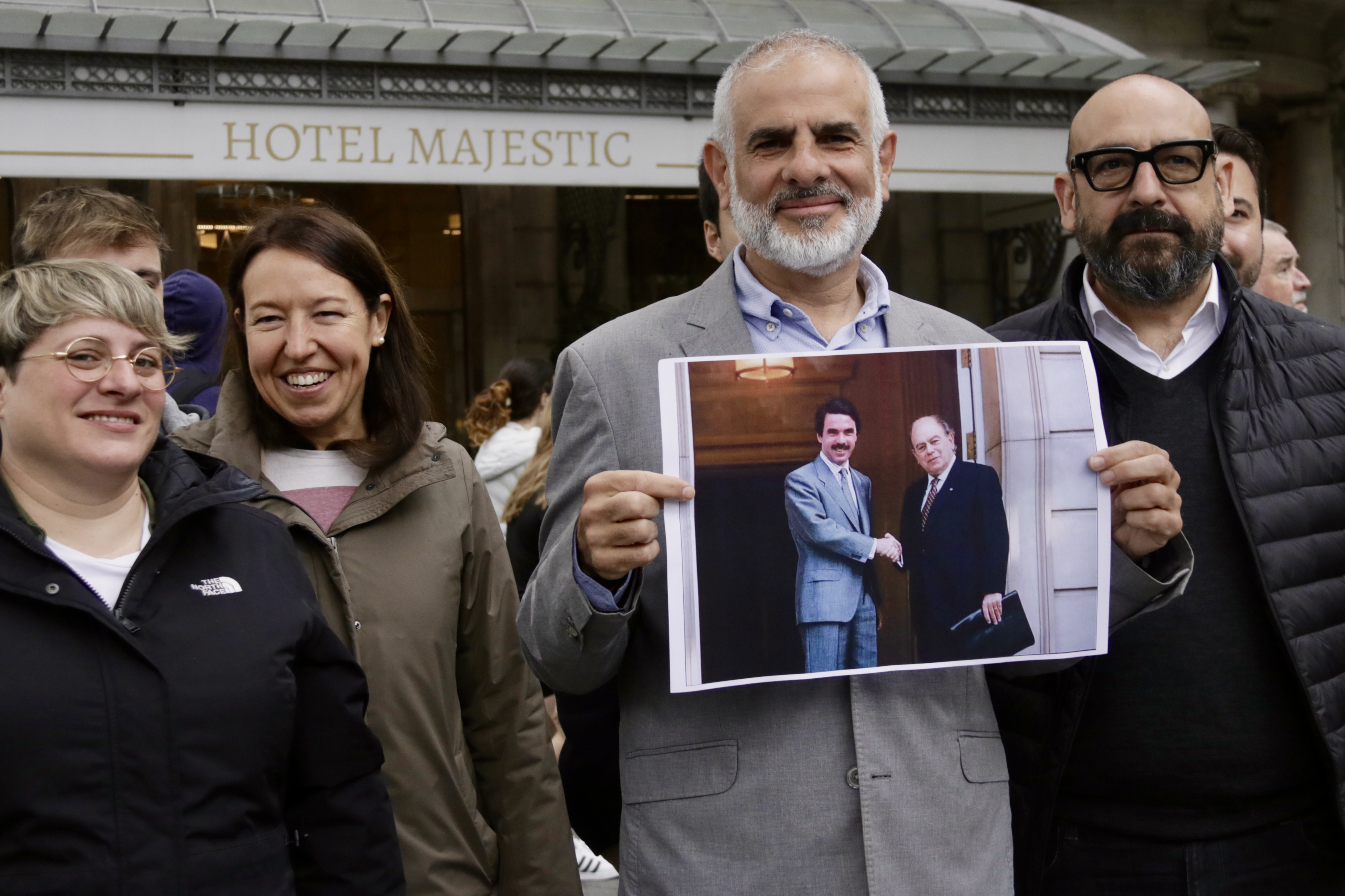 El candidat de Cs, Carlos Carrizosa, amb la imatge del pacte del Majestic, davant l'hotel barceloní, per denunciar els acords del PP amb el nacionalism