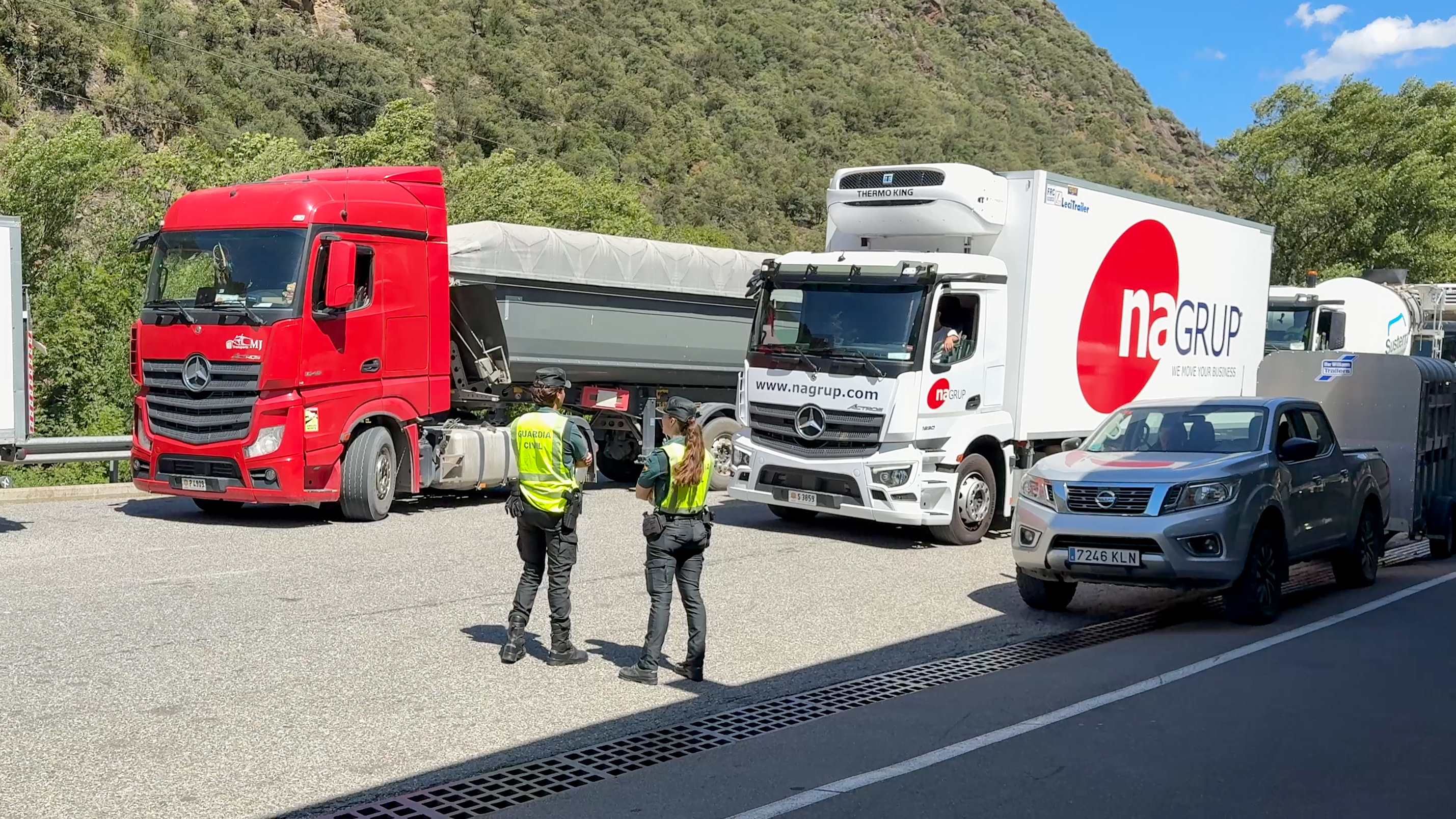 Civil Guard officers wave heavy goods vehicles through at Farga de Moles