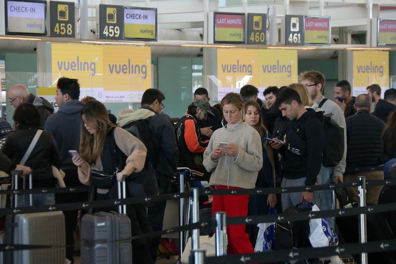 Passengers waiting to check in at Barcelona Airport