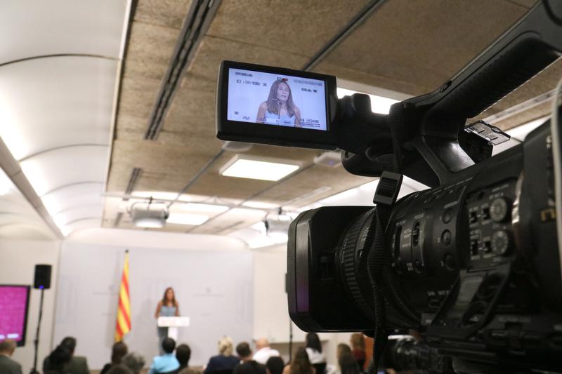 A news camera at a political press conference