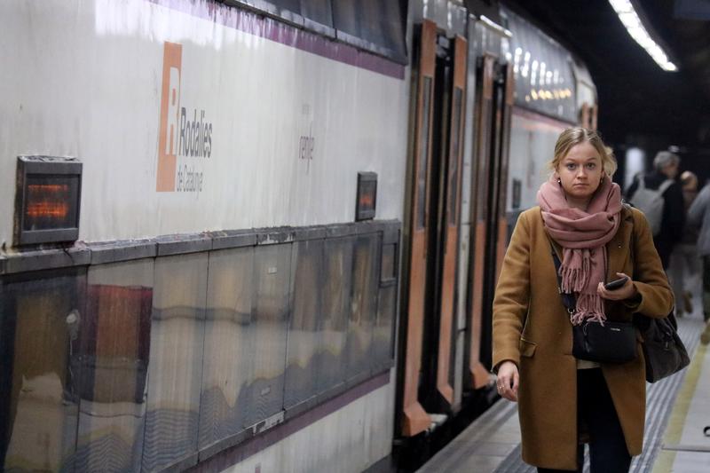 A public transport user walks down Sants train station's platforms without a face mask on the first day of the mandate being lifted on February 8, 2023