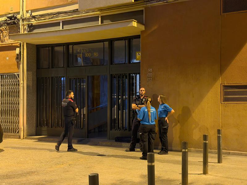 Police and emergency services at the door of the apartment where a woman was killed