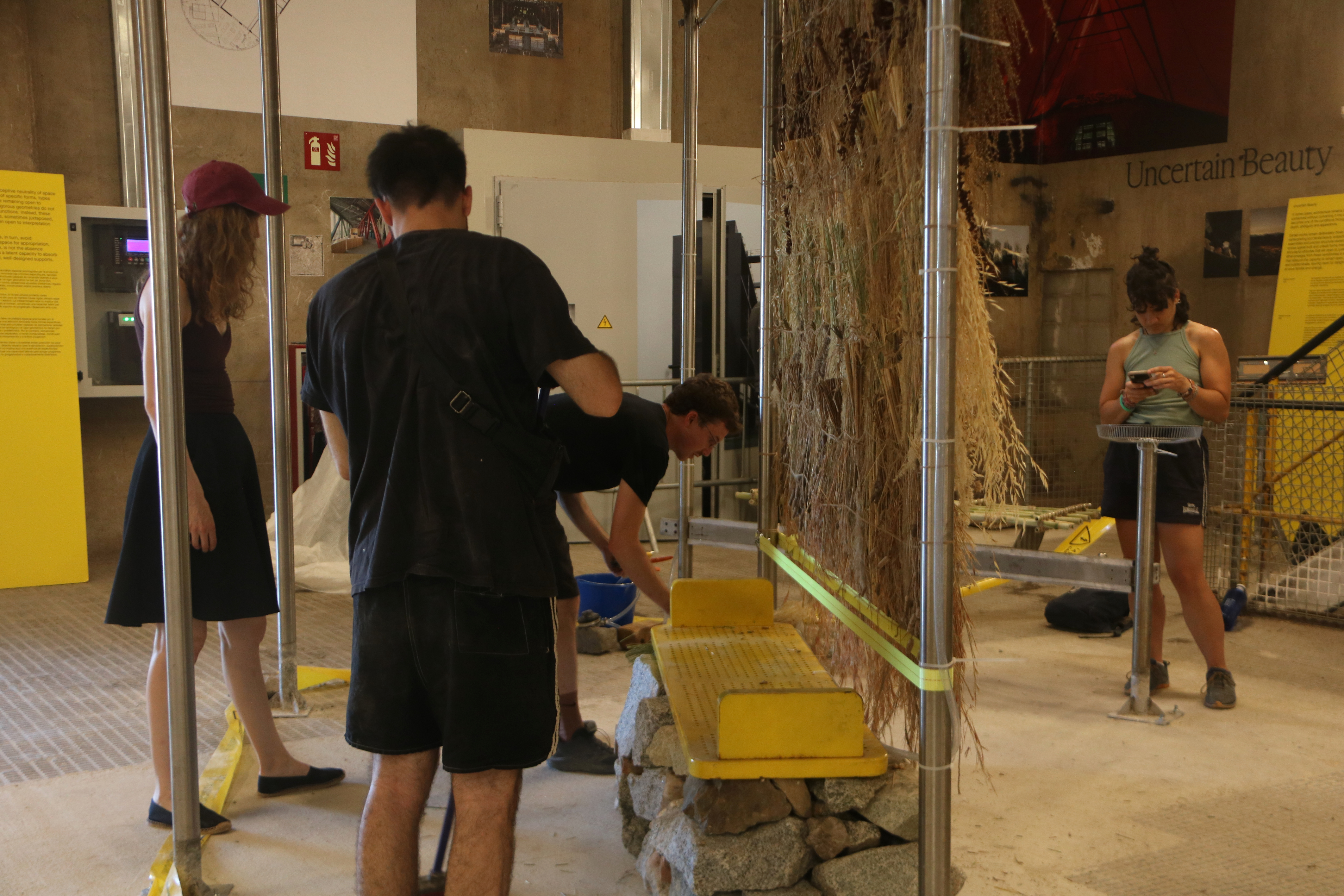 Several people finishing one of the spaces of the central exhibition of the UIA World Congress of Architects 2026 Barcelona at Les Tres Xemeneies