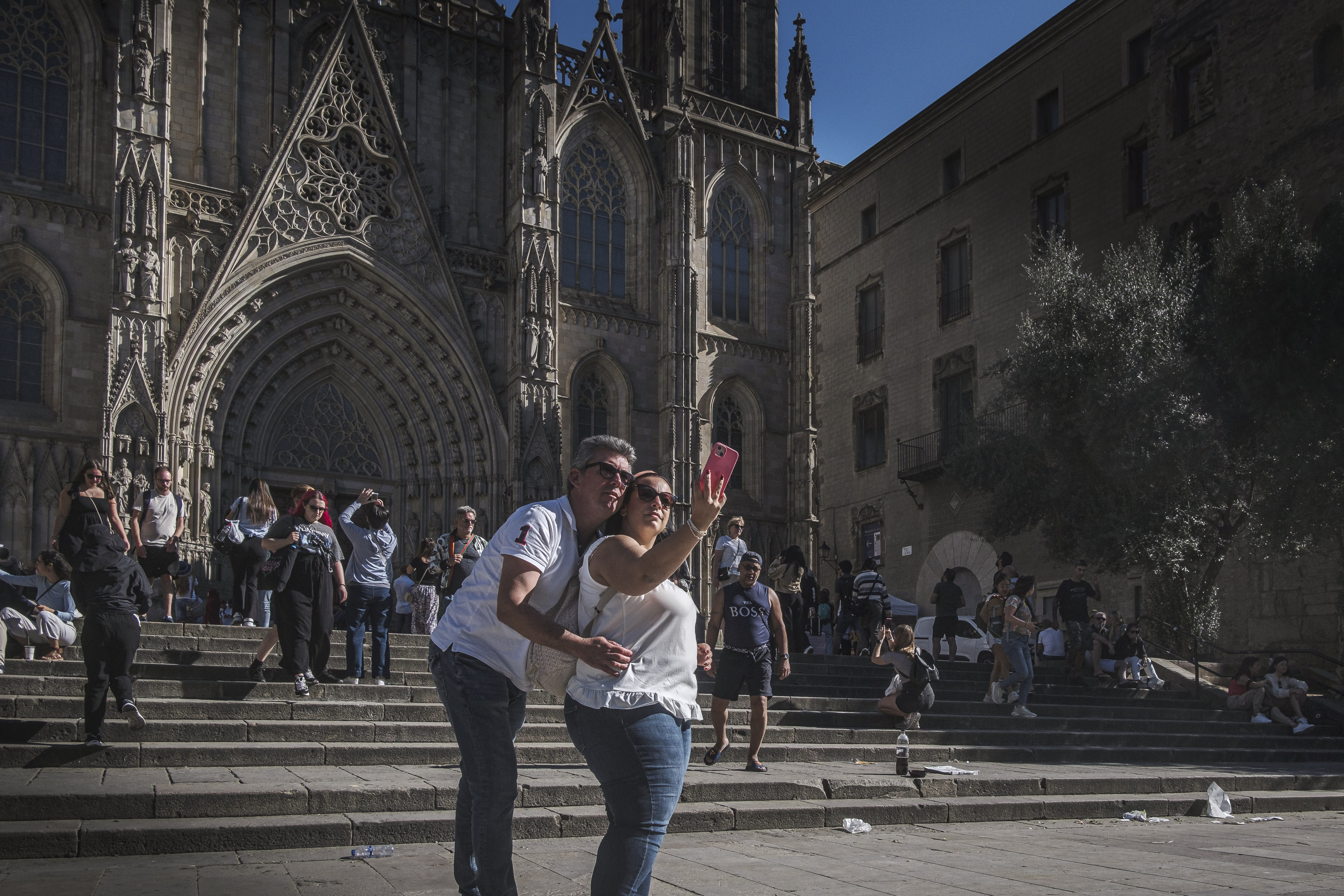 Two tourists take a selfie in front of Barcelona's Cathedral