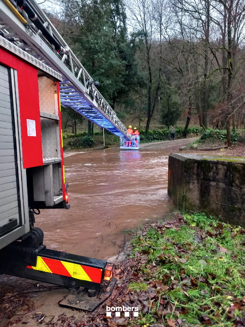 Firefighters use a lorry to evacuate a group of stranded people due to the Gurn river running at full capacity in Vall d'en Bas