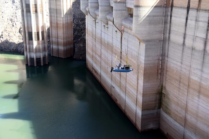 A boat is lowered by crane into the Sau reservoir as part of the fish cull operation