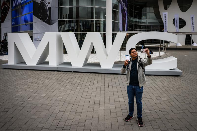 A MWC attendee taking a photo before entering the venue in Barcelona