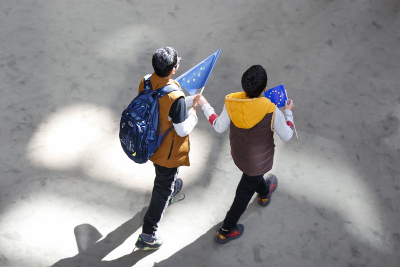 Two people holding two European flags during a visit at the European Parliament in Strasbourg on April 27, 2024