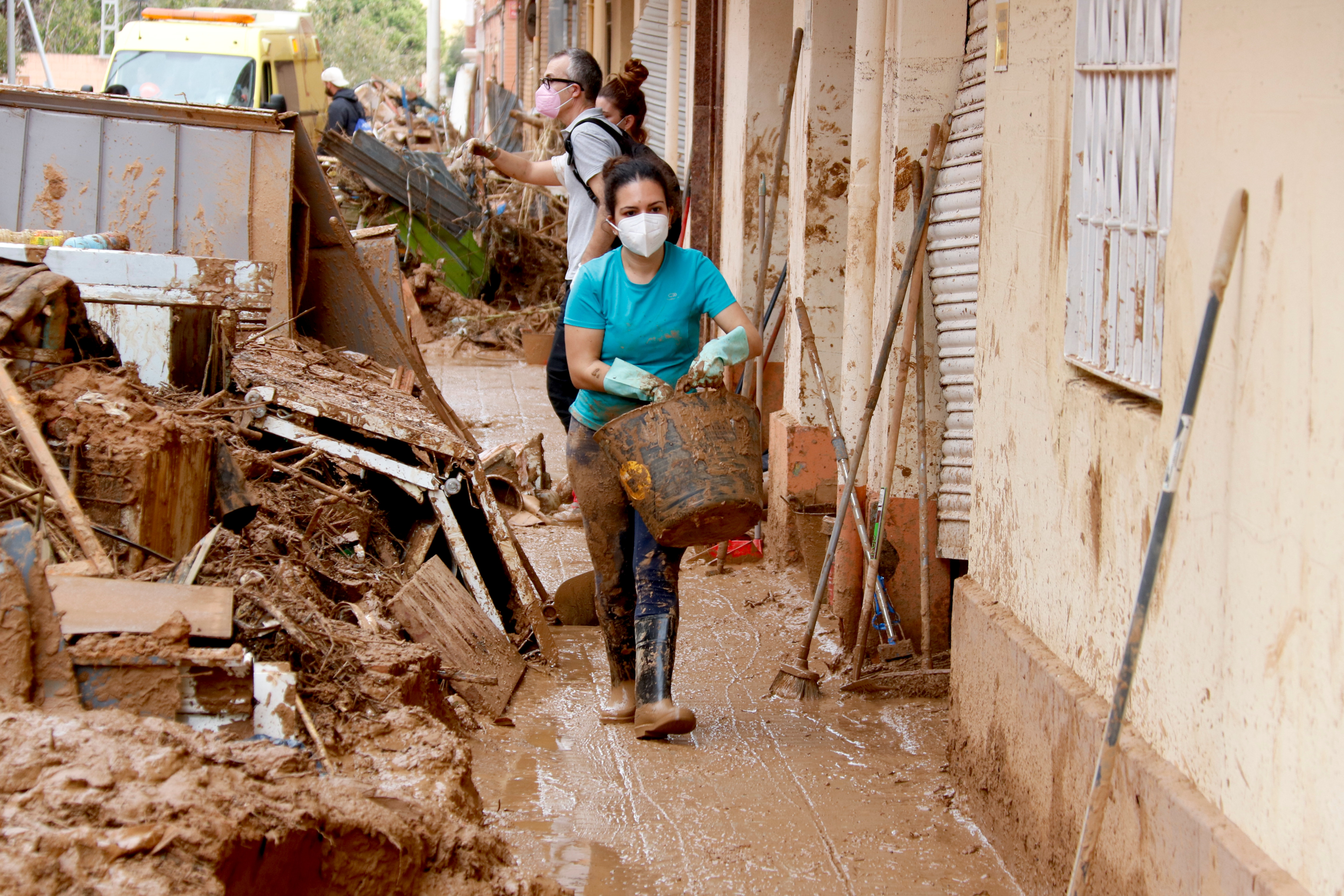 A local cleans up mud from a building in Paiporta