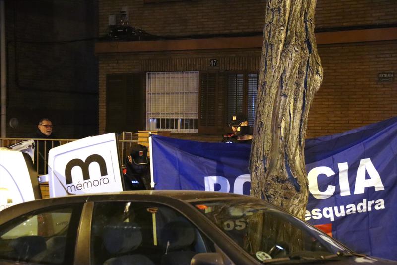 Police agents outside the Barcelona flat where the bodies a man and two children were found