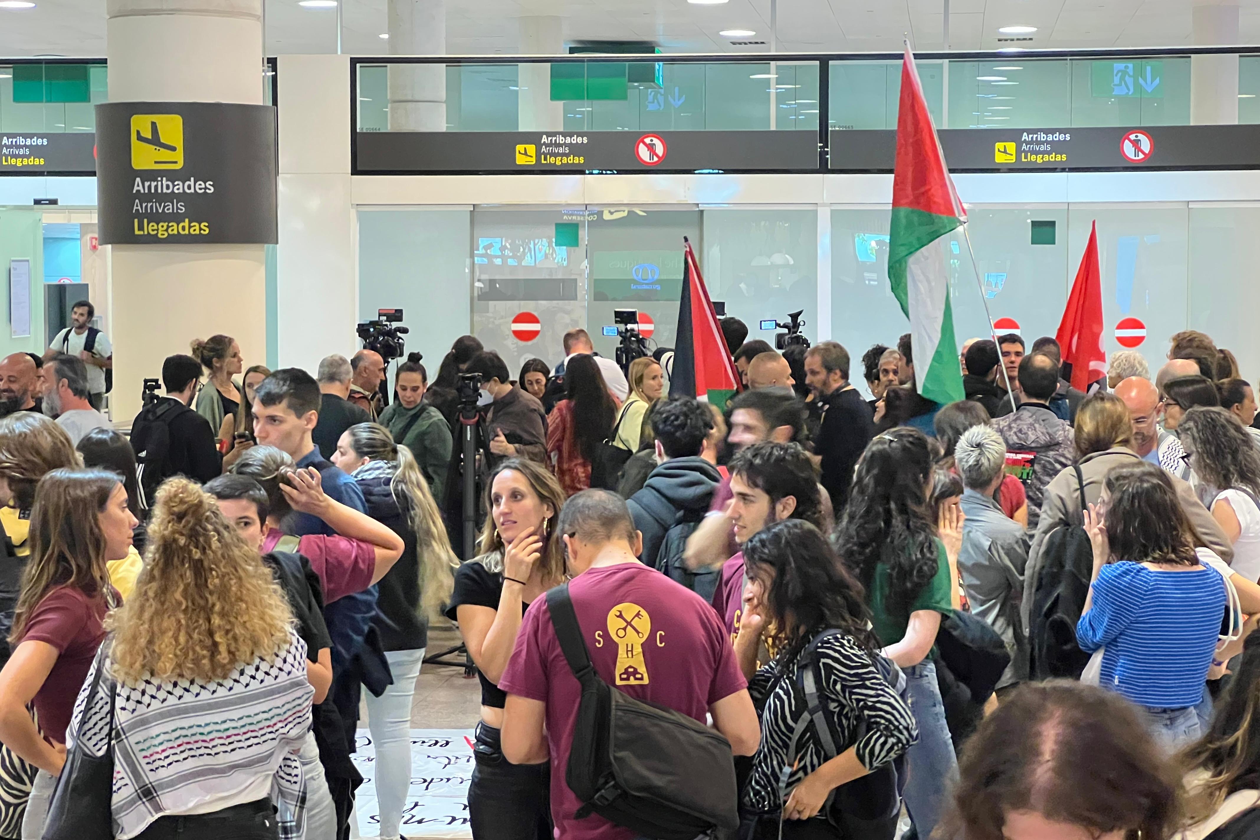 Dozens of people await in the Barcelona airport for members of the Global Sumud Flotilla to arrive from Israel