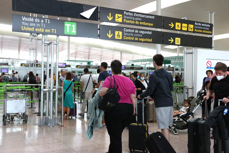 People traveling through Barcelona airport security checkpoint on July 30, 2022