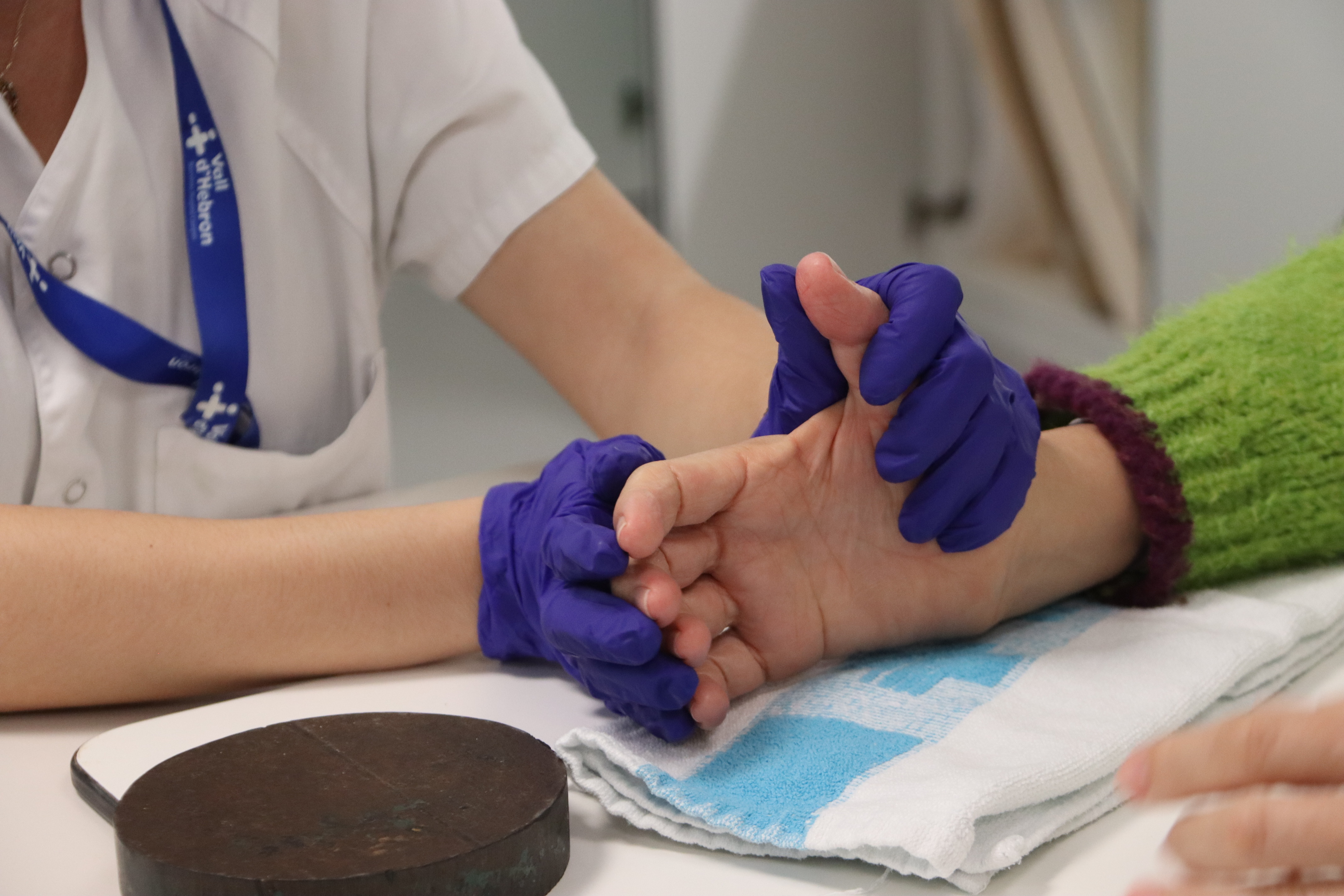 An occupational therapist holds a patient’s hand during a rehabilitation exercise