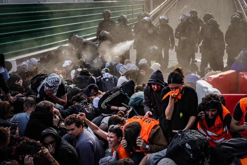 Police pepper spray protesters sitting on the ground outside Sants Station