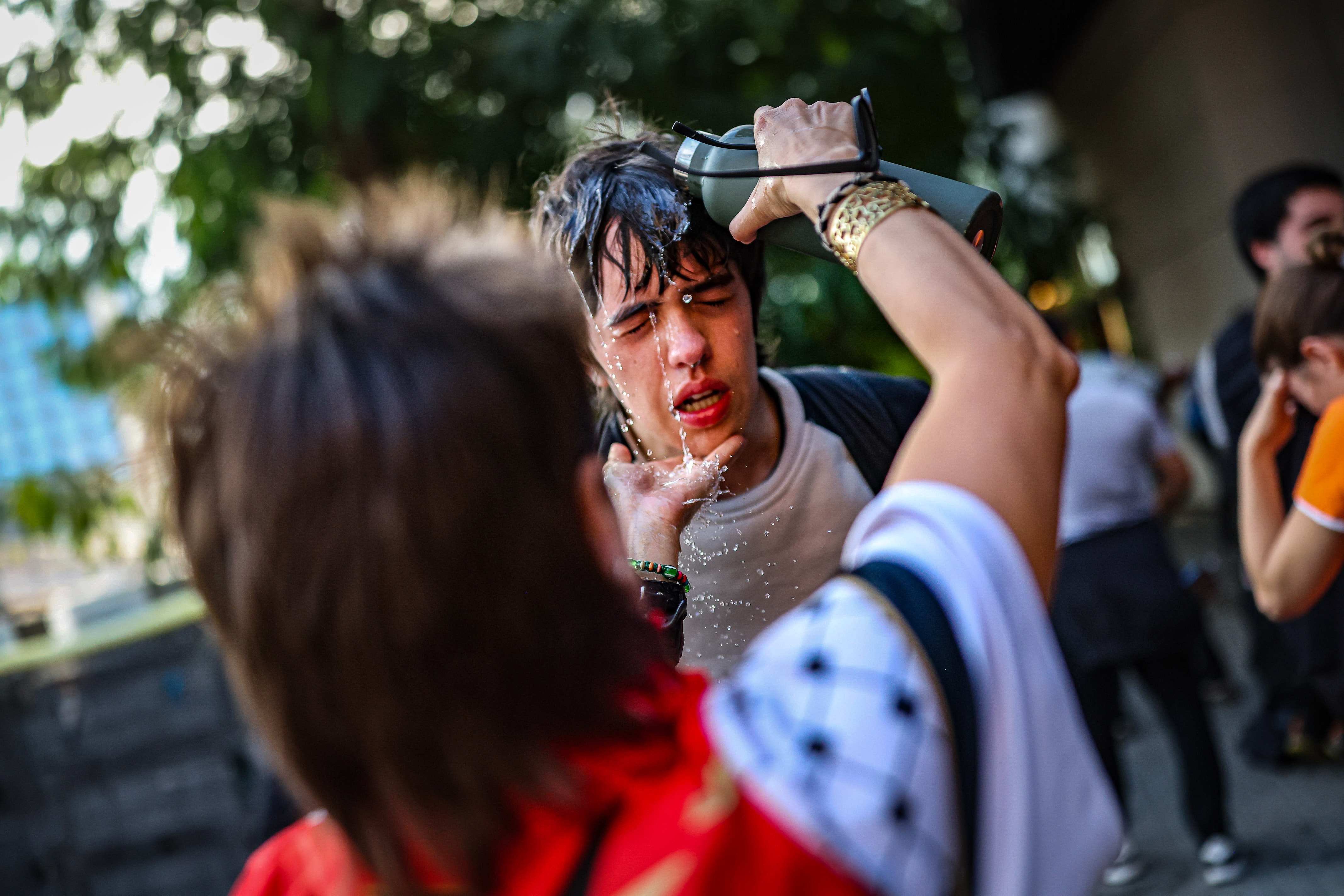Un manifestant li posa aigua a un altre després que els Mossos hagin ruixat amb gas pebre una seguda