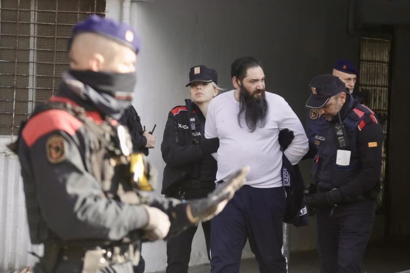 Catalan police officers arrest a man as part of a police operation in La Mina