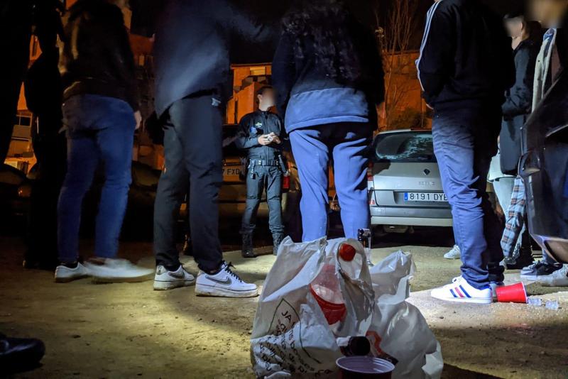 Several youngsters next to a bag with alcoholic beverages in Reus