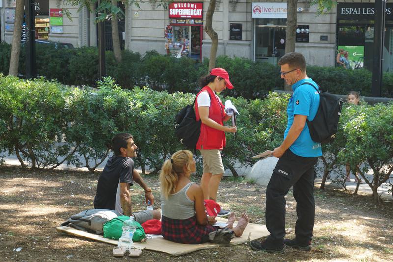 Service workers attend to a homeless couple in Barcelona as part of the city council's heat plan 