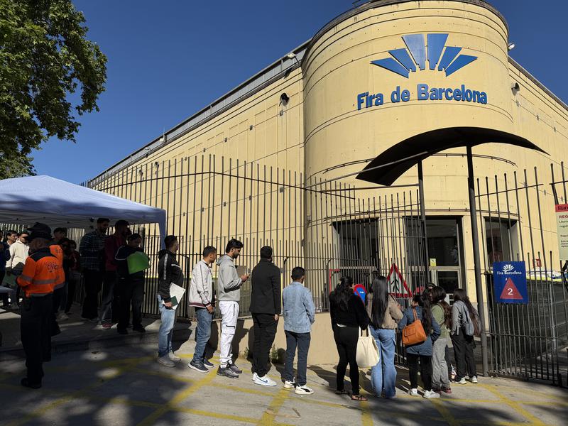 Migrants queue at Fira de Montjuïc for the regularisation process