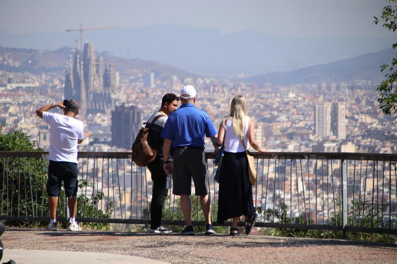 Tourists admire the view of Barcelona from Montjuïc