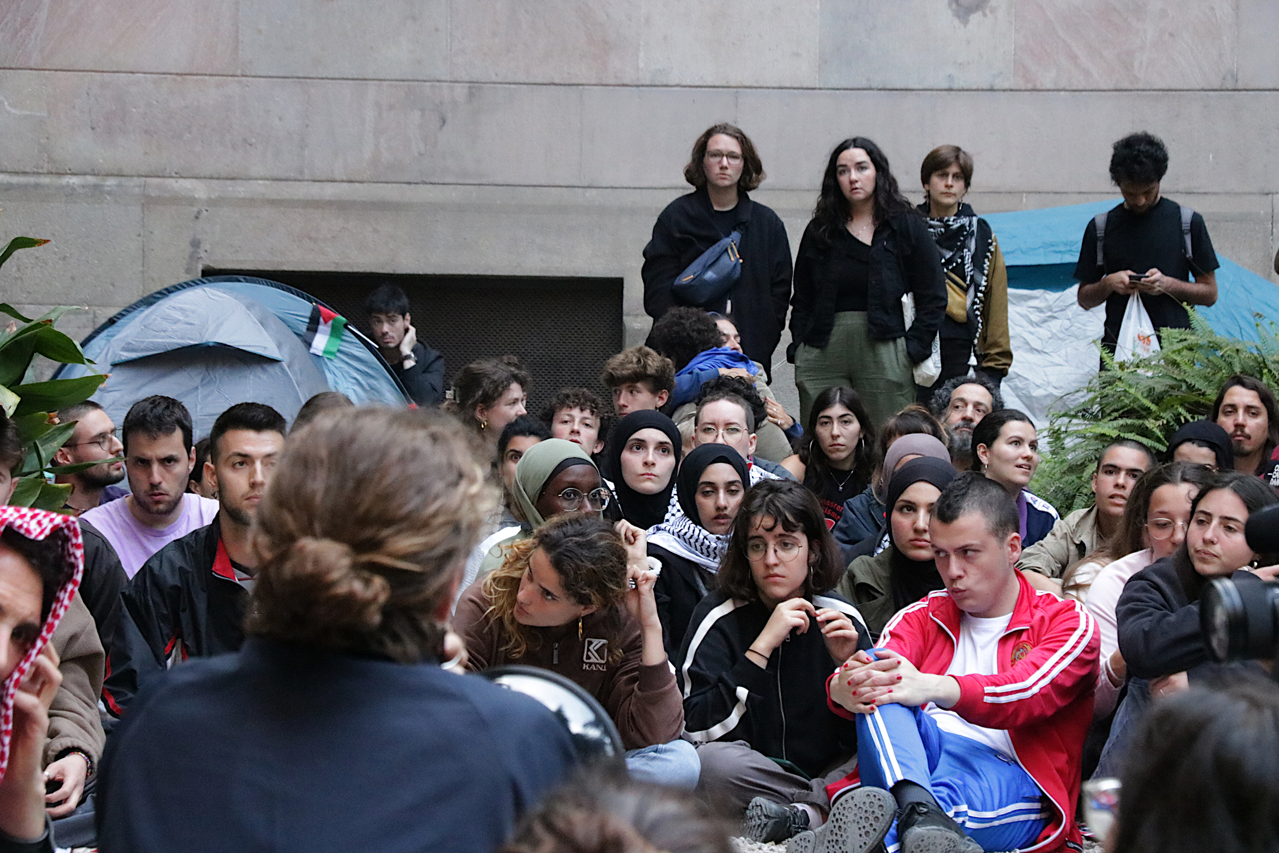 Un estudiant donant pautes a alguns dels concentrats al claustre de l'edifici històric de la UB.