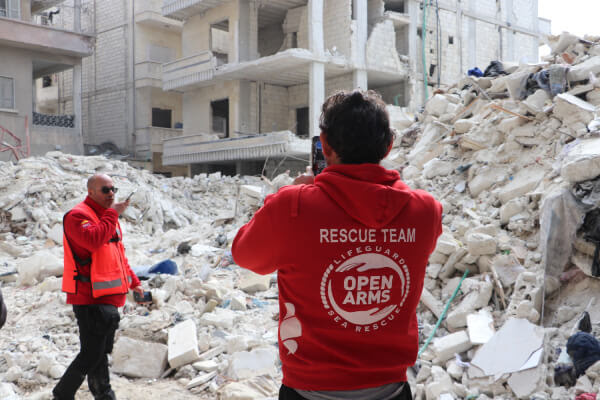 A member of the Open Arms and SAR-Navarra aid team in Syria in front of a destroyed building
